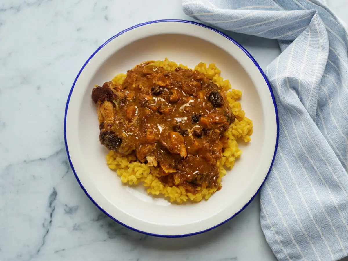 tajine de poulet marocain aux fruits secs, garni de coriandre & amandes