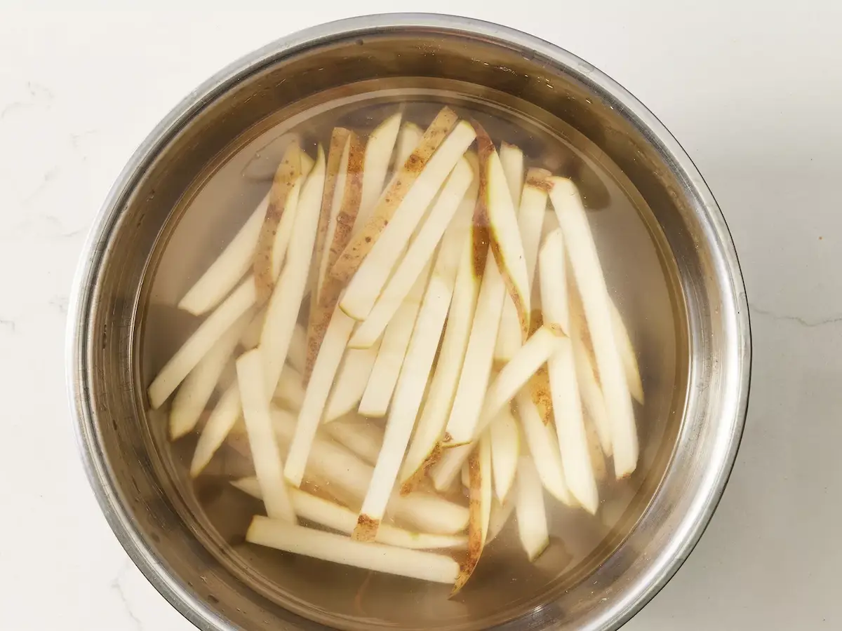 bâtonnets de pomme de terre qui trempent dans l’eau froide