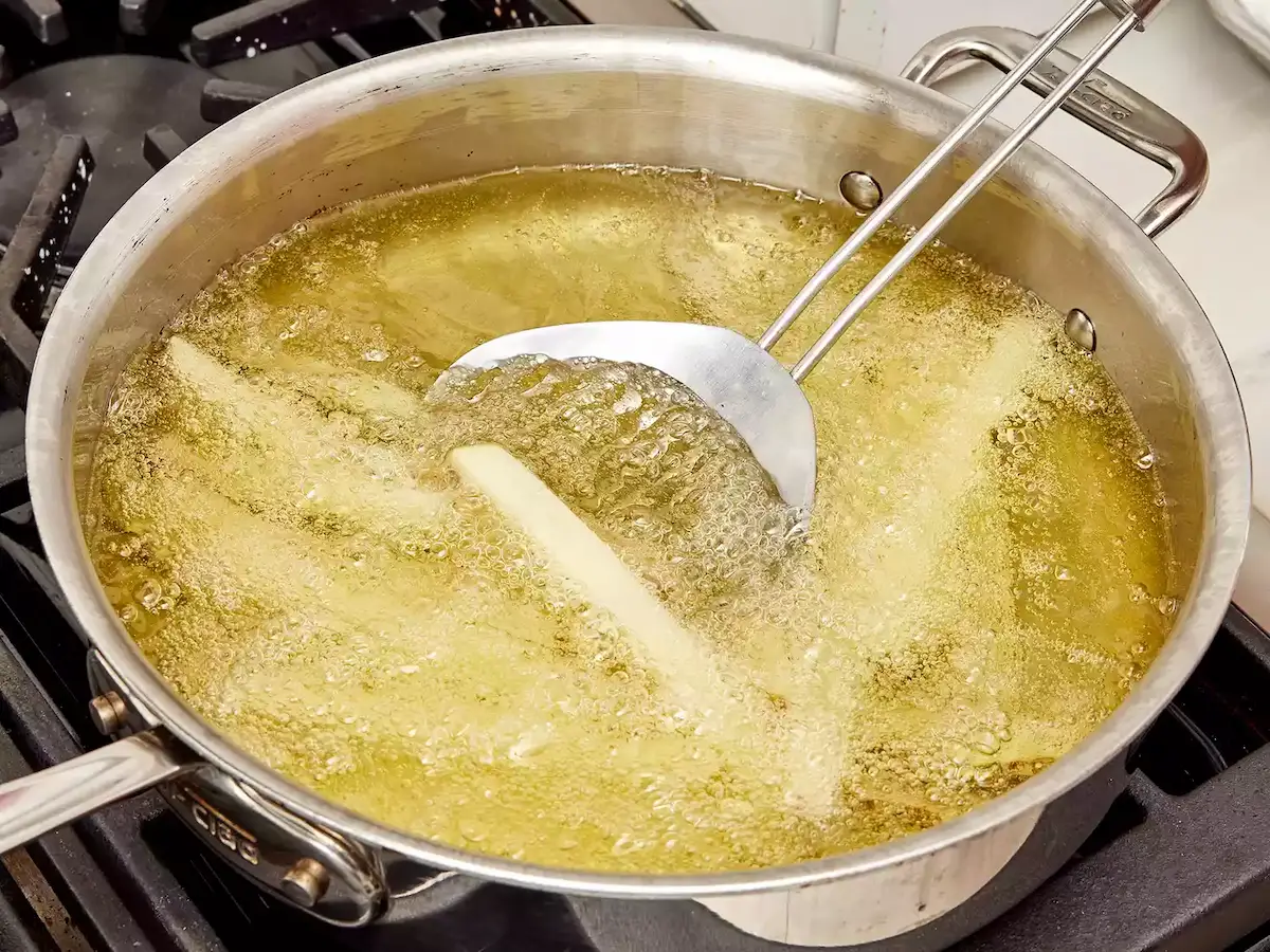 première friture à température modérée, frites encore pâles