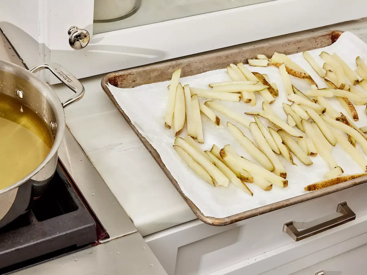 frites précuites égouttées sur papier absorbant, prêtes à refroidir