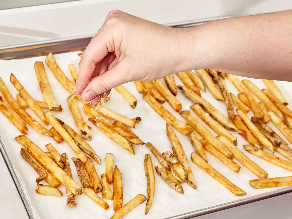 frites dorées égouttées, sel ajouté à la surface