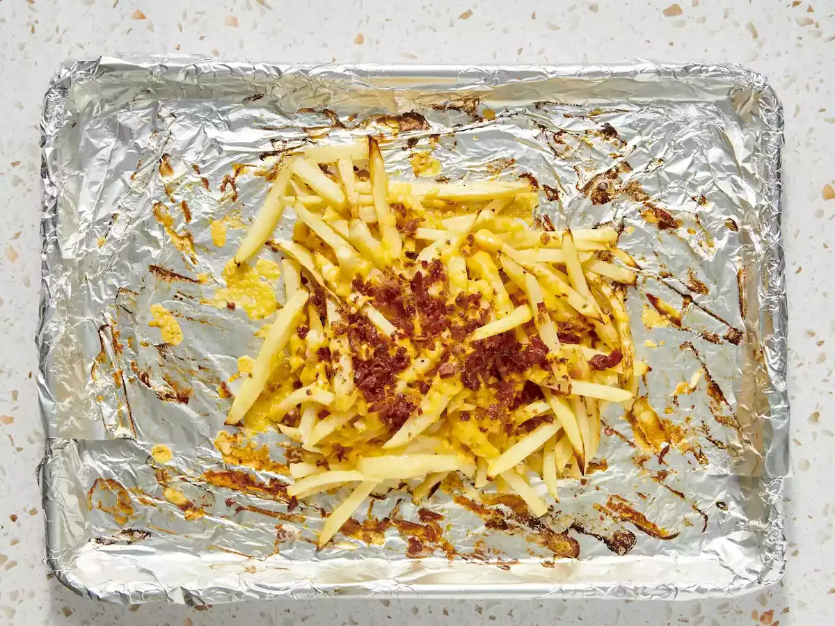 frites recouvertes de cheddar fondu et d’éclats de bacon sur plaque