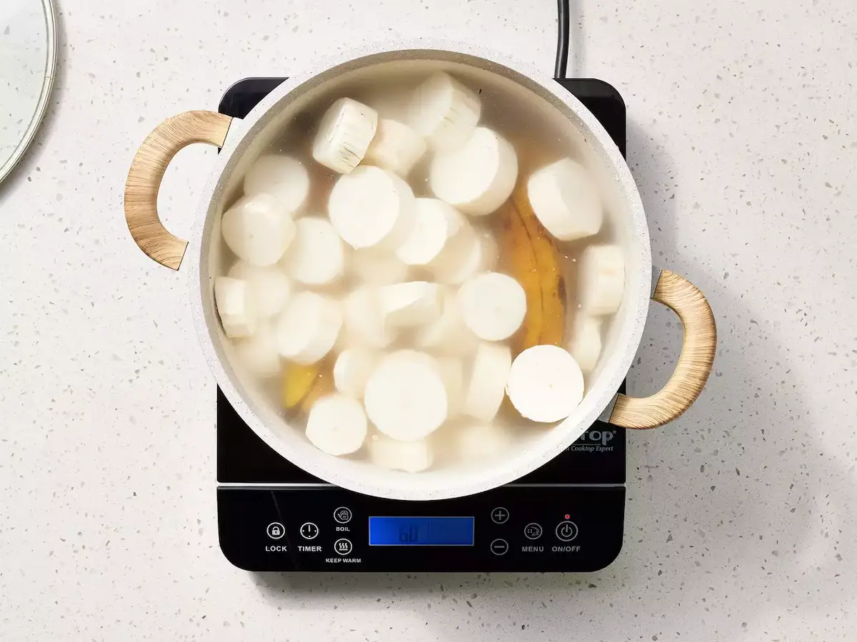 manioc tranché et plantains dans la marmite, recouverts d’eau avant cuisson
