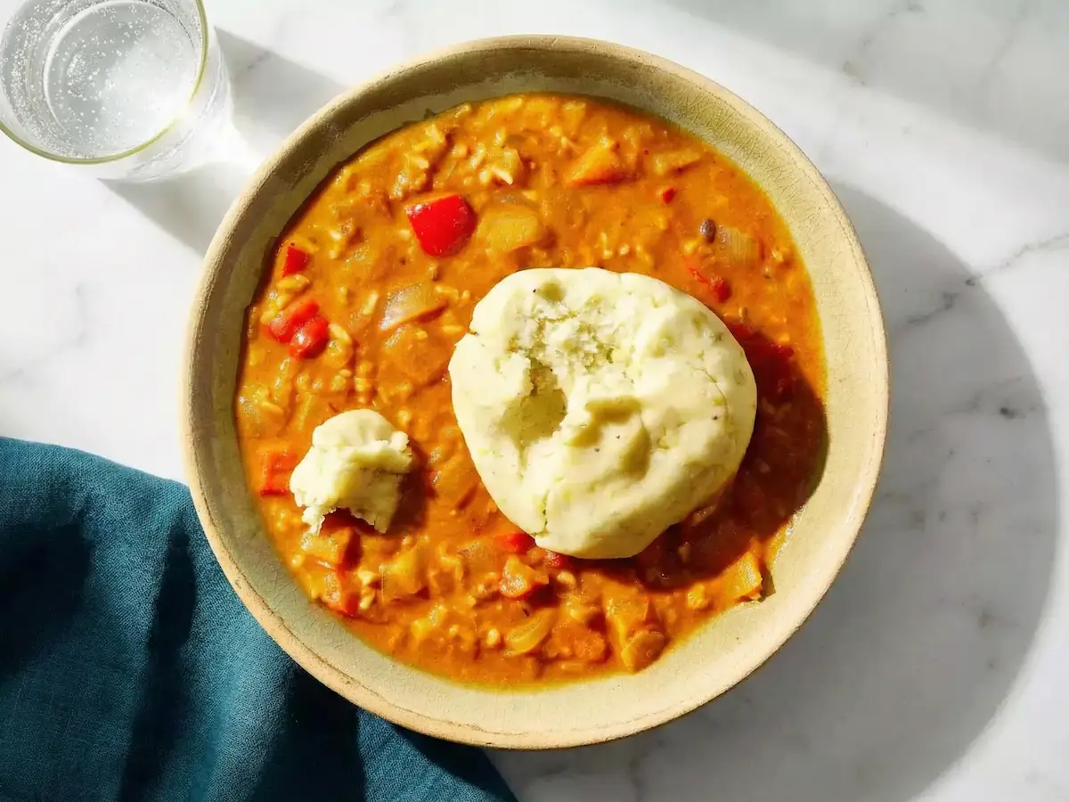 fufu en boules lisses servi avec une soupe d’arachide, dans un bol fumant